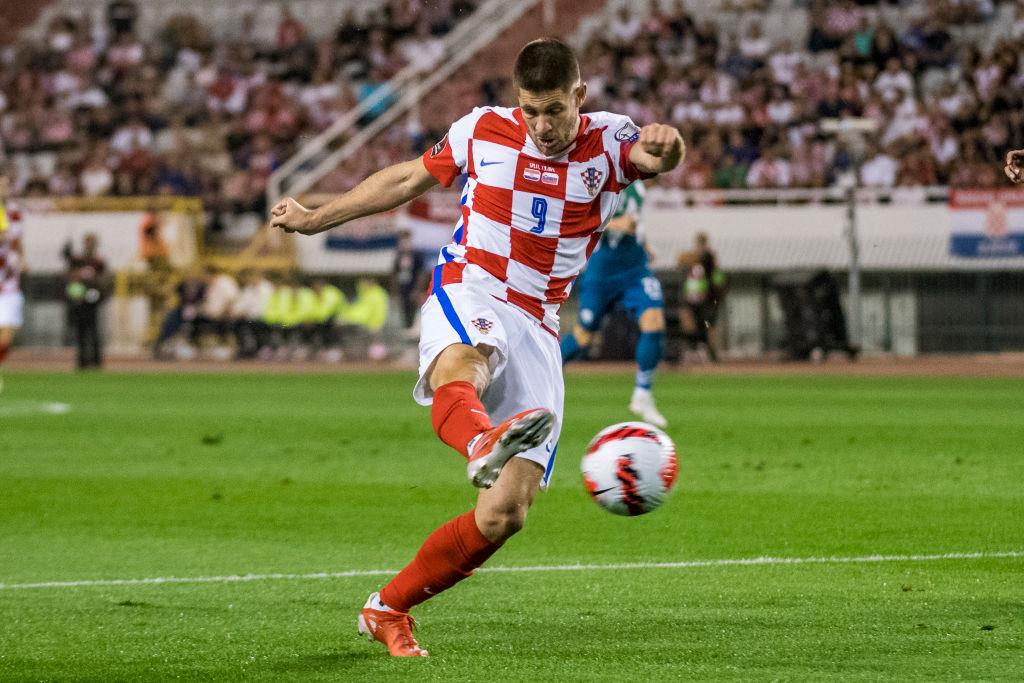 Hrvatski nogometaš u dresu s kockicama šutira loptu na utakmici reprezentacije